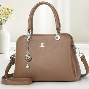 Brown lychee leather crossbody bag with top handle and silver heart charm decoration