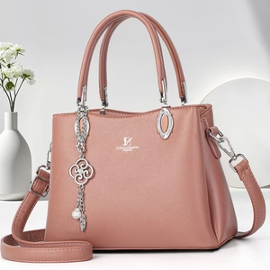 Pink faux leather handbag with adjustable strap and metal charm for women