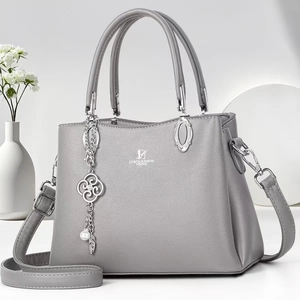 Detail of grey lychee textured leather bag with silver David Jones Paris logo and floral charm