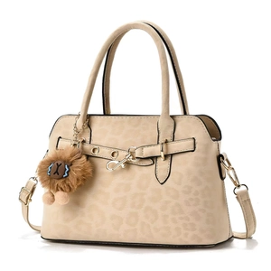 Detail of vintage leopard print handbag featuring gold buckle and plush lion charm