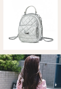 Detail of silver quilted mini backpack featuring shiny leather texture and chain strap