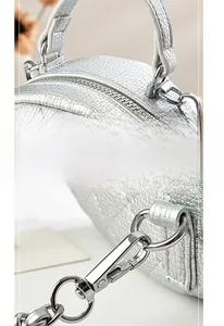 Detail of silver quilted leather handbag showing thick comfort handle and metallic hooks