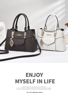 Détail de sacs cabas à motifs marron et blanc avec pendentifs feuilles et ferrures