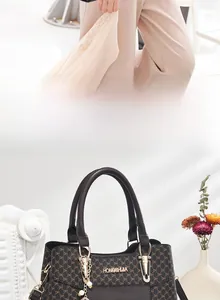 Détail du sac cabas marron foncé avec motif logo, plaque dorée et breloque perle