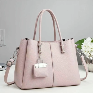 Elegant light pink pebbled leather tote bag with double handles and adjustable strap