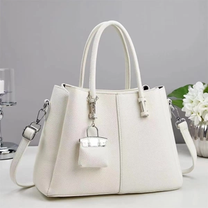 Detail of white lychee grain leather tote bag with silver hardware and detachable strap