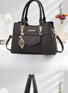 Détail du sac à motif monogramme avec pendentif feuille dorée et bandoulière