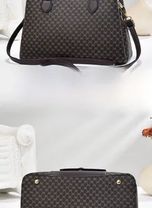 Détails du sac marron à motif DH montrant la base renforcée avec pieds en métal doré
