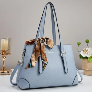 Sac à main bleu clair en similicuir avec texture grainée et foulard décoratif sur la poignée