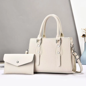 Detail of cream leather tote bag with pebble texture and matching envelope wallet set