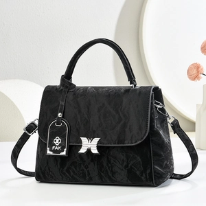 Detail of black wrinkled leather handbag with silver butterfly buckle and FAK charm