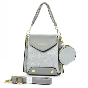 Detailed view of grey tote bag with woven texture, round coin purse, and leather shoulder strap