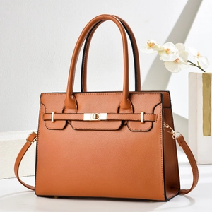 Macro detail of brown lychee grain leather with gold twist lock on stylish handbag