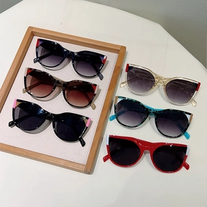 Flat lay of cat-eye sunglasses in various colors like tortoiseshell and red frames