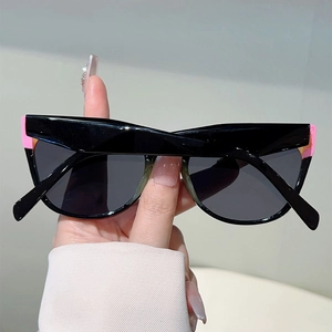 Close-up of cat-eye sunglasses with stylish pink and orange color-block frame detail