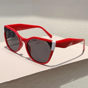 Detail of red oversized sunglasses featuring geometric color-block accents on frame