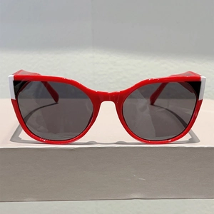 Detail view of red cat-eye sunglasses featuring bold black and white geometric accents
