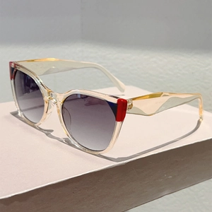 Detail view of bold two-tone champagne sunglasses with red and blue color block accents