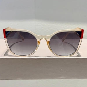 Detail of cat-eye sunglasses with champagne frames and color-block accents on corners