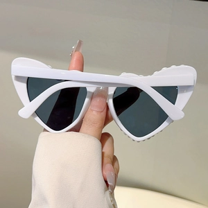 Détail de lunettes de soleil blanches en cœur avec incrustations de perles et verres gris