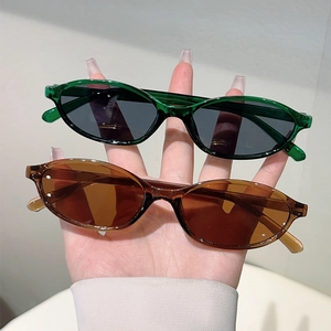 Detail view of vintage oval sunglasses in translucent green and tea brown resin frames