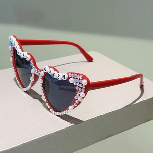 Détail de lunettes de soleil cœur rouge avec perles, strass et lettres Birthday Queen