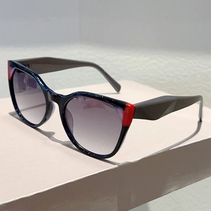 Close-up of cat-eye sunglasses with gradient purple lenses and red color-block detail