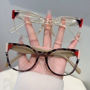 Detail of cat-eye glasses frames in clear and tortoiseshell colors with color-block accents