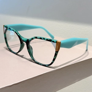 Detail of teal cat-eye glasses frame with tortoise pattern and gold metal accents