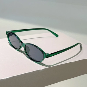 Detail view of vintage green translucent oval frame sunglasses with dark lenses