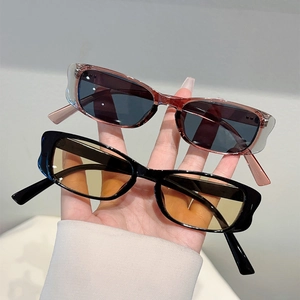 Detail view of retro rectangular sunglasses with transparent red and black frames