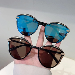 Detail of cat eye sunglasses with blue and brown lenses featuring golden metal frames