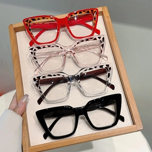 Detail view of four multi-color cat-eye anti-blue light glasses on a wooden tray
