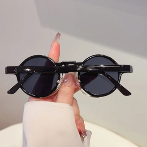Close-up of retro round black frame sunglasses with glossy finish and dark lenses