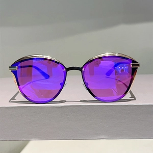 Detail of purple cat-eye mirror lenses with a slim pale gold metal frame for sunglasses