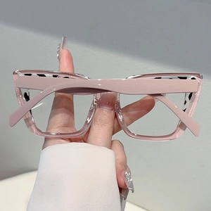 Detail of oversized pink glasses frame with leopard print accents on temples