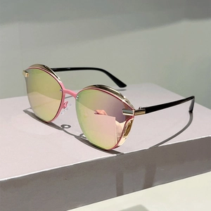 Detail of pink and black cat-eye sunglasses with gold accents and colorful mirrored lenses