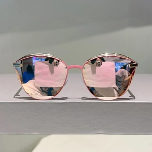 Detail of pink cat-eye sunglasses featuring reflective mirror lenses and metal accents