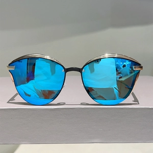 Detailed close-up of cat-eye sunglasses with gold metal frame and blue mirrored lenses