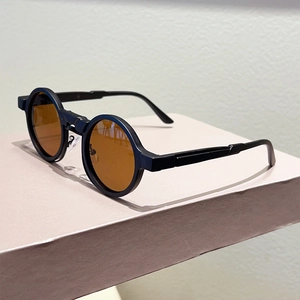 Detail view of vintage round sunglasses with matte black frame and amber lenses