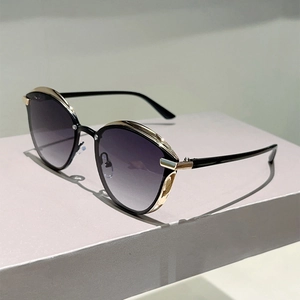 Detail of cat eye sunglasses with black frame and golden metal accents on the side