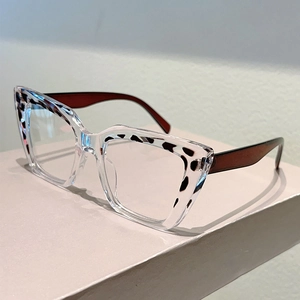 Detail of cat-eye glasses frame featuring transparent resin and leopard print accents
