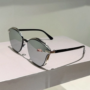 Detail of modern cat-eye sunglasses with silver mirrored lenses and black frame