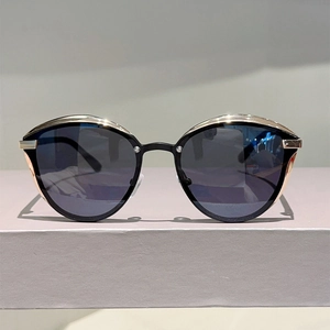 Detailed shot of cat eye sunglasses featuring black frames and gold metal edge detailing