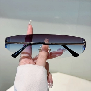 Détail de lunettes Y2K sans monture avec verres dégradés bleu-violet et branches en métal