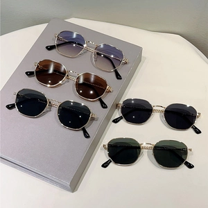Vintage metal frame sunglasses with multiple lens colors shown on a geometric display stand