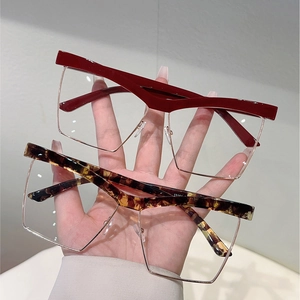 Detail of burgundy and tortoise cat-eye frames with wide browline and metal lower rim