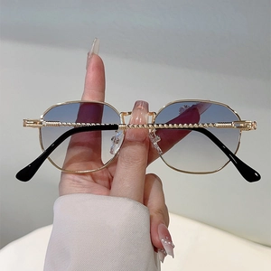 Detail of slim gold metal frame with rope texture and gradient blue-grey sunglasses lenses