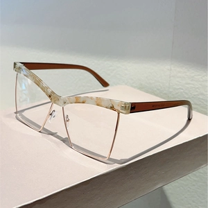 Detail of cat-eye glasses frame with marble texture and gold metal rim on a stand