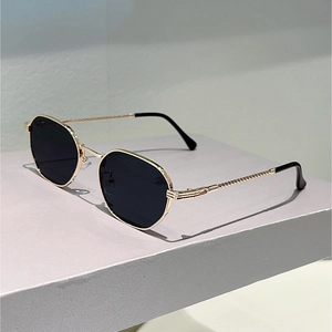 Close-up of retro metal sunglasses with unique twisted rope texture on the gold temples